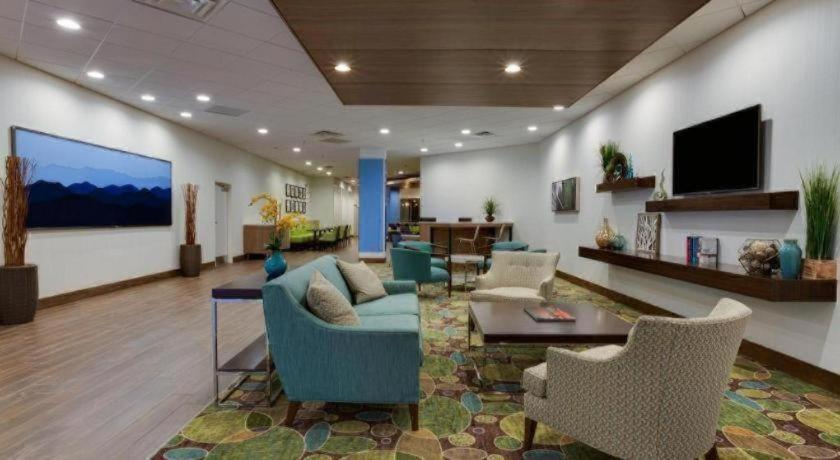 a lobby with a couch and chairs and a tv at Holiday Inn Express Wilkesboro By IHG in Wilkesboro