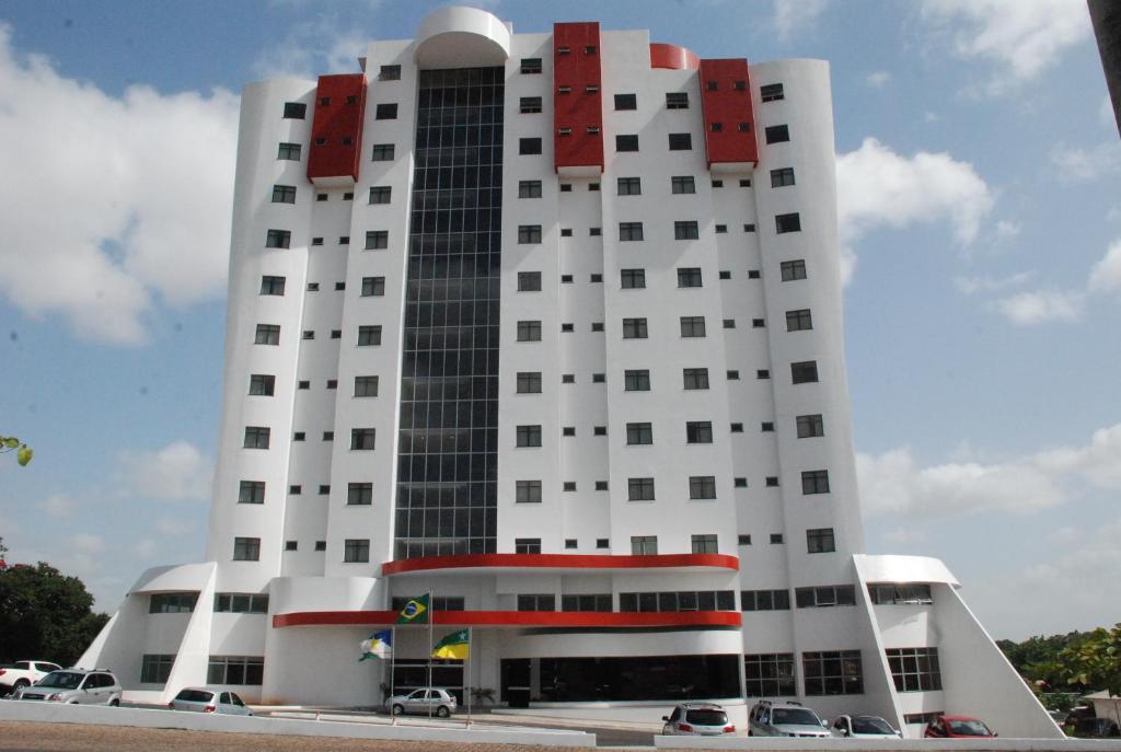 a white building with cars parked in front of it at Boa Vista Eco Hotel in Boa Vista