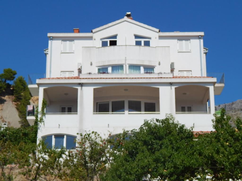 a white building with trees in front of it at Apartments Sofija in Podstrana