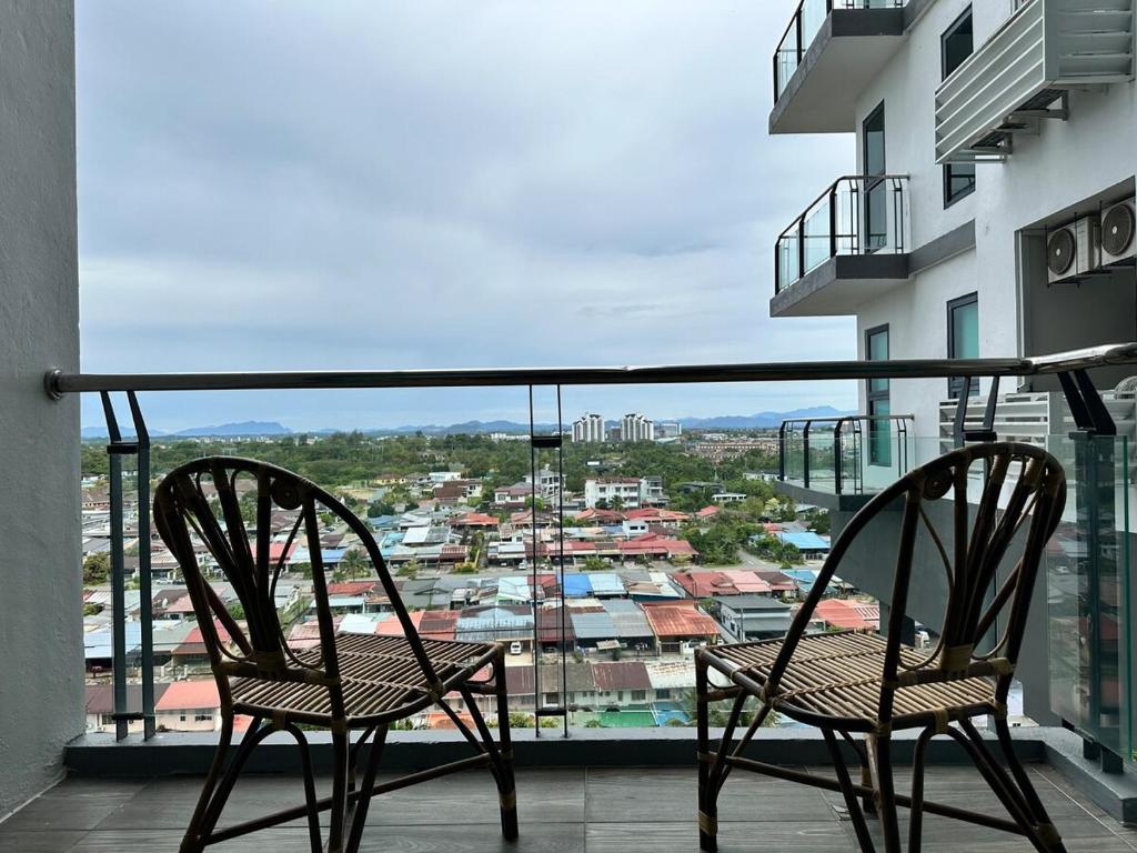 Dos sillas en un balcón con vista a una ciudad. en Vivacity Jazz Suite 3 by De Kumang Homestay, en Kuching