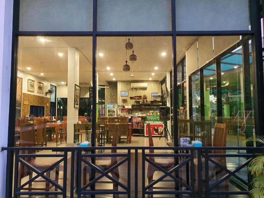 Blick auf ein Restaurant mit Tischen und Stühlen in der Unterkunft Phuphayot Resort in Huai Yot