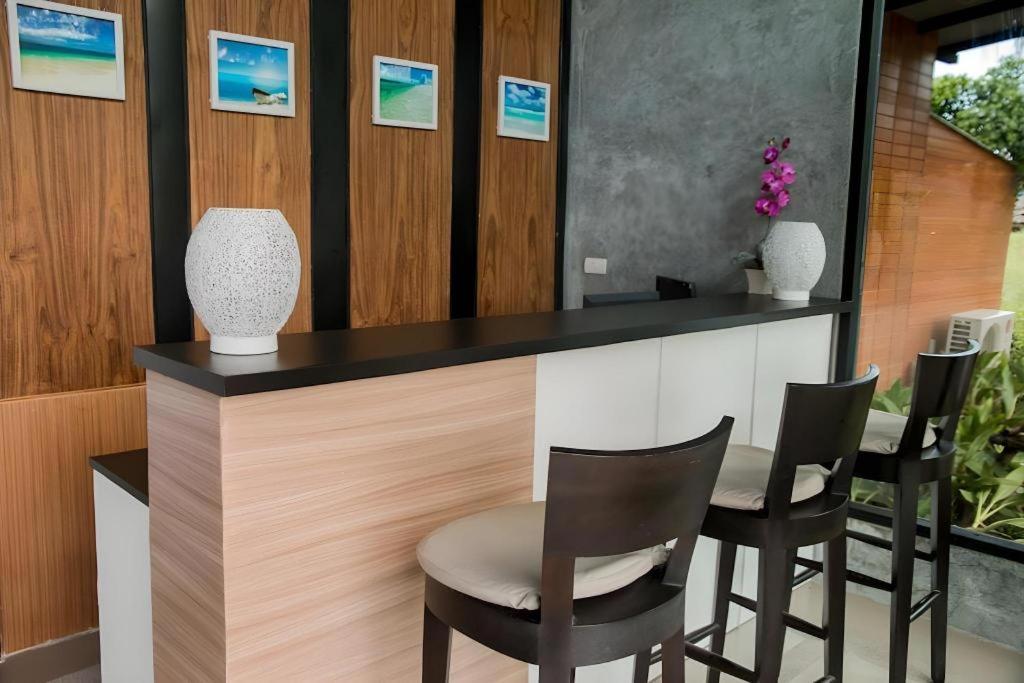 un bar avec des chaises noires et blanches et un comptoir dans l'établissement Panwana Resort, à Ban Taphong Nok