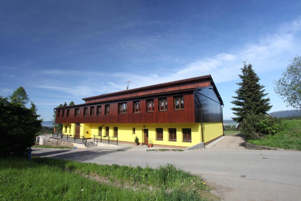 un grande edificio con un rosso e un giallo di Penzion PANORAMA Janovičky a Broumov