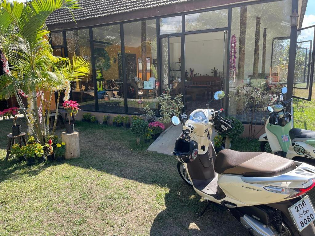 a scooter parked in front of a house at Aroma Pai Spa Hotel in Ban Tha Pai