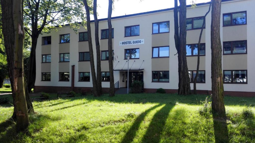 a building with trees in front of it at Hostel Guido in Zabrze