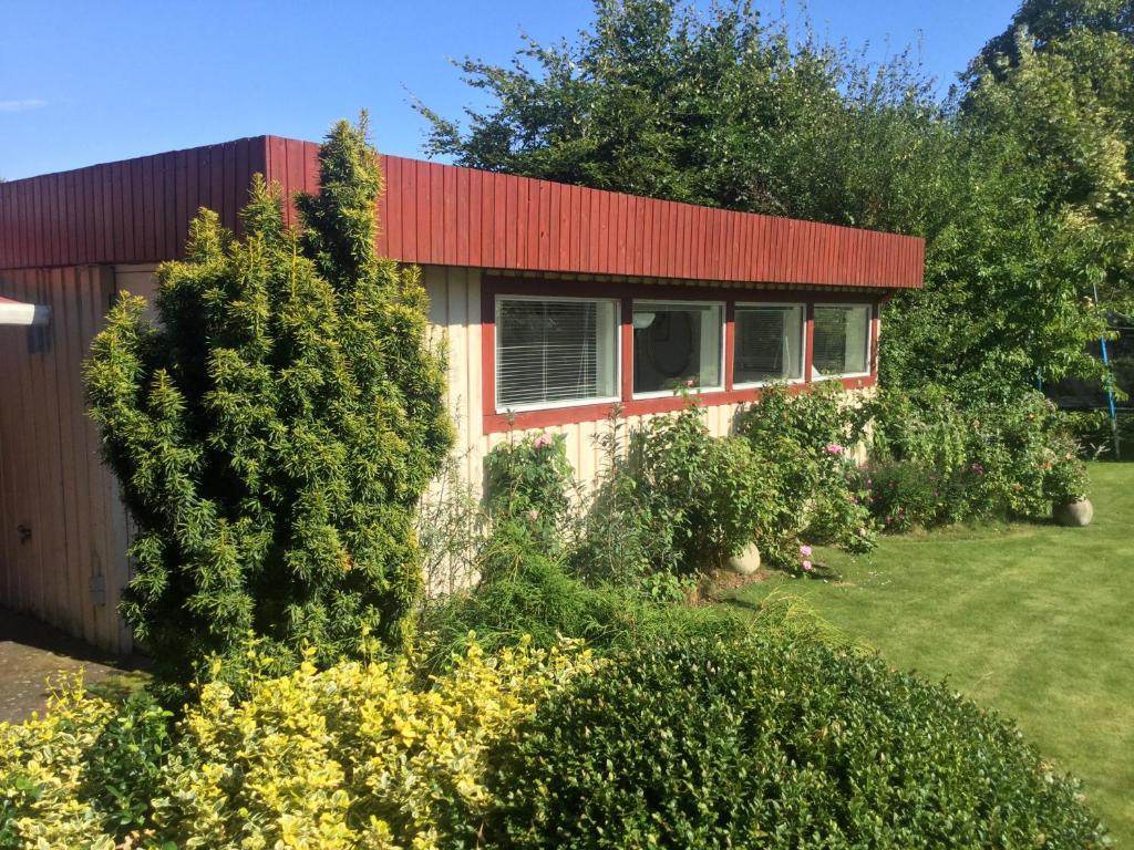 een huis met een rood dak en wat struiken bij Risskov Bellevue Guesthouse in Aarhus