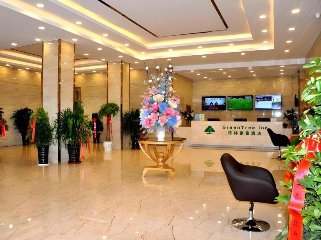 eine Lobby mit einem Blumenarrangement in einem Geschäft in der Unterkunft GreenTree Inn Haixi Geermu Southern suburbs Express Hotel in Golmud