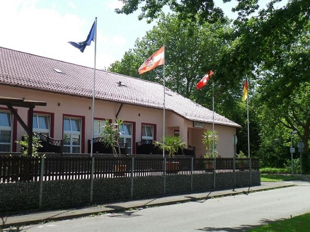 un bâtiment avec drapeaux devant lui dans l'établissement Hotel Heuschober, à Friedrichshafen