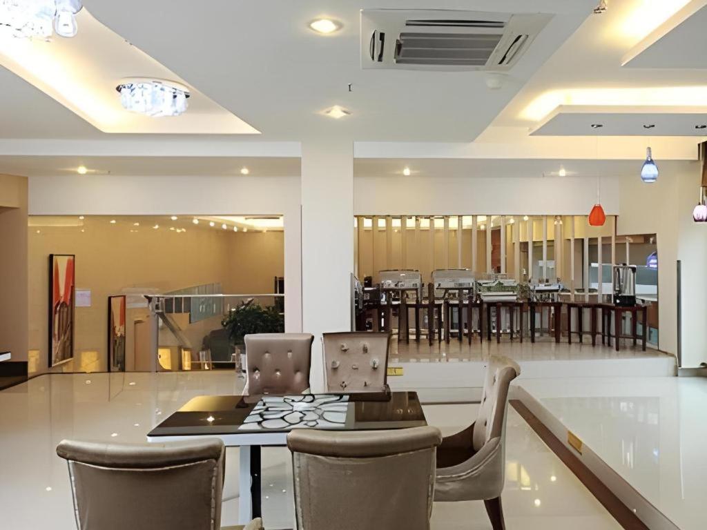 ein Esszimmer mit einem Tisch und Stühlen sowie eine Cafeteria in der Unterkunft GreenTree Inn Taizhou Gaogang District Business Hotel in Sixiang