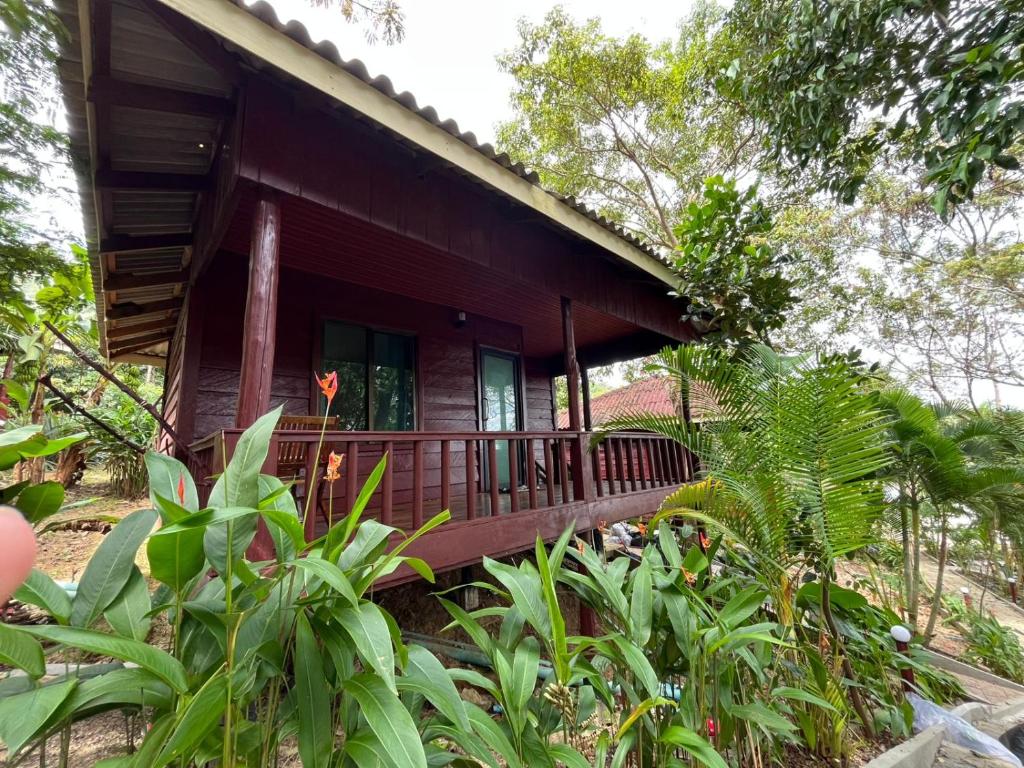 ein kleines Holzhaus mit einer großen Veranda in der Unterkunft Roomy Bungalows in Phumĭ Kâoh Rŏng