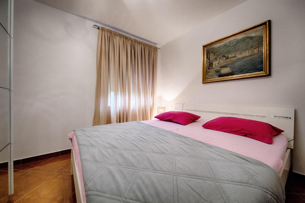 a bedroom with a large bed with red pillows at Apartments Nikola Vidović in Komiža