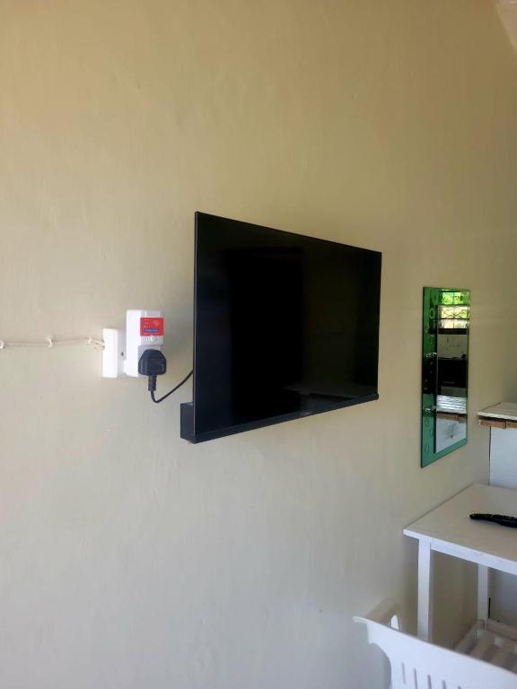 a flat screen tv hanging on a wall at Cozy studio in Malindi