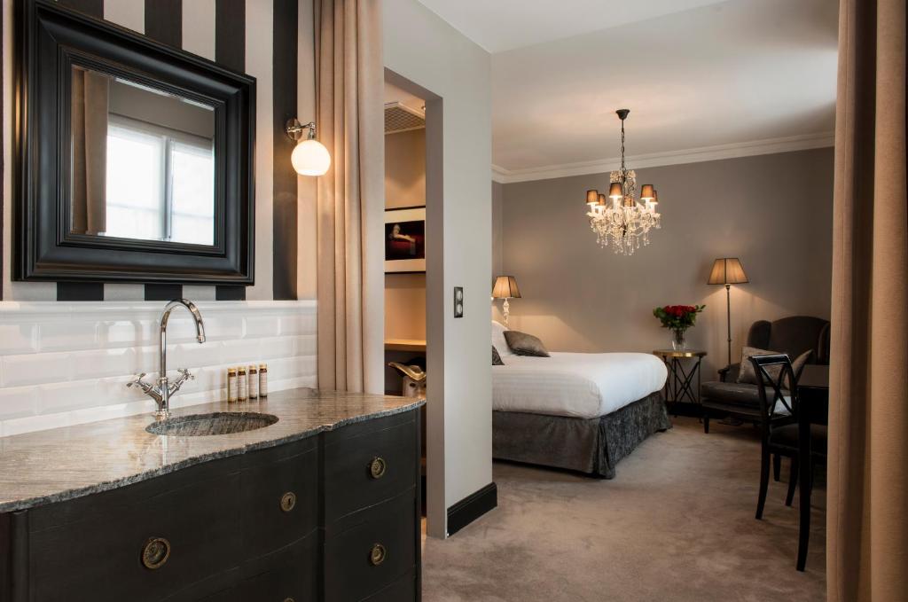 パリにあるヴィラ グラモーのベッドとバスルーム付きのホテルルームです。