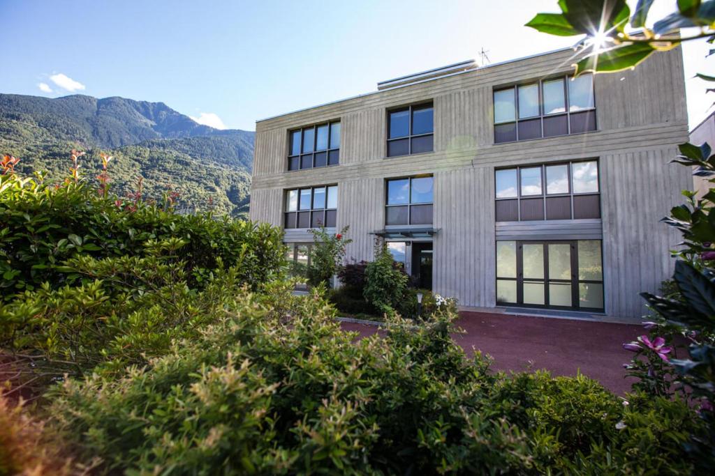 an exterior view of a building with mountains in the background at Residence al Lido in Caiolo