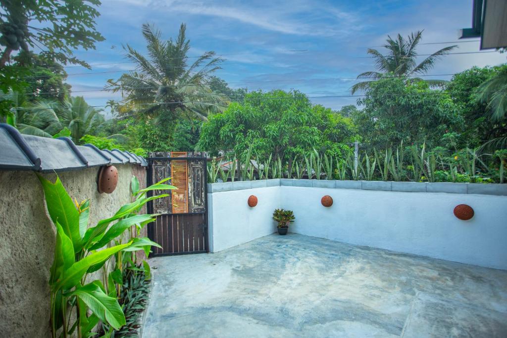 a gate to a house with trees in the background at Amora Villa in Galle