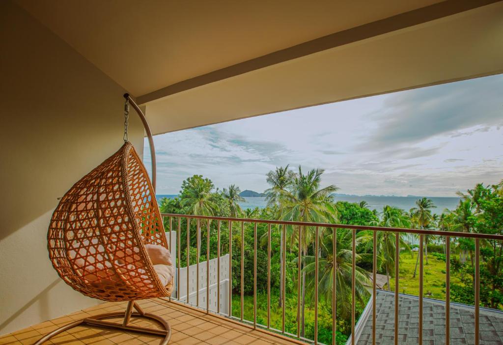 a hammock on a balcony with a view of the ocean at Treetop Bliss Villa by Sea N' Rent in Koh Phangan