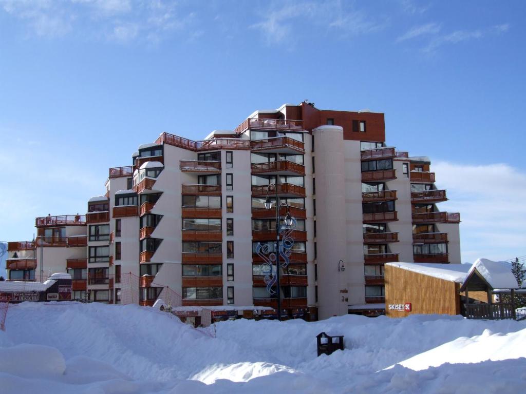 a large apartment building in the snow with a building at Trois Vallées Appartements VTI in Val Thorens