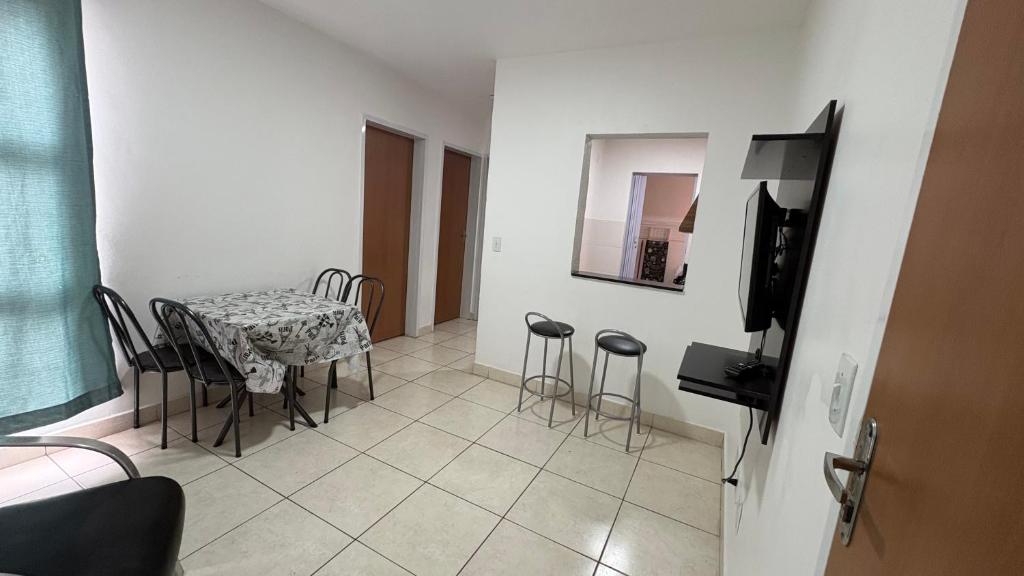 a dining room with a table and chairs and a television at Apartamento in Rio Verde