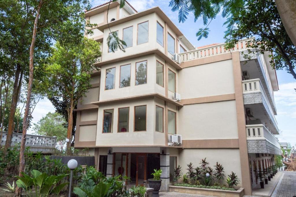 ein großes weißes Haus mit Bäumen davor in der Unterkunft Nipah Island Resort in Setengh