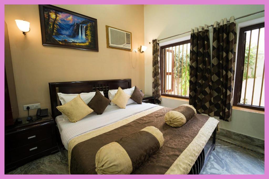 une chambre avec un grand lit et deux fenêtres dans l'établissement VIP Lane MC Palace Resort - Air Conditioning Room # Best PREMIE LOCATION - Chakra Tirtha Road, Puri, à Purî