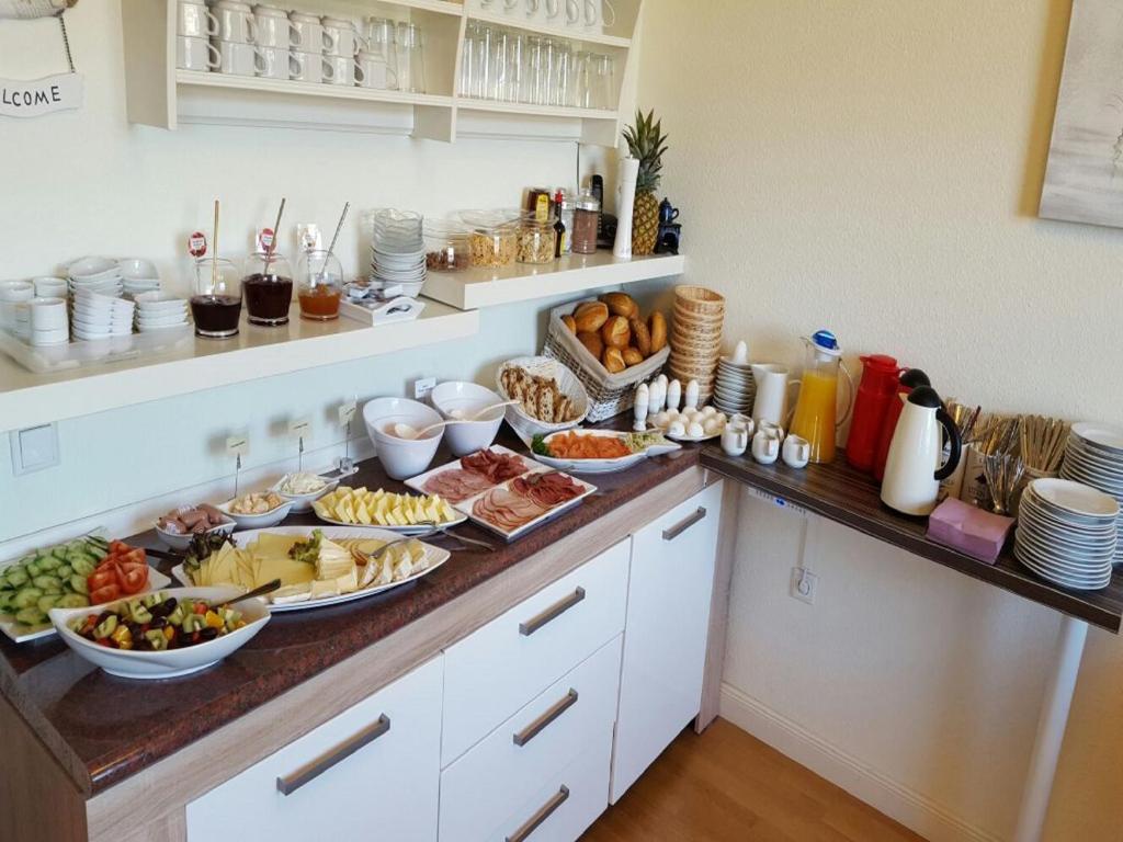 ein Buffet mit Speisen auf einer Theke in einer Küche in der Unterkunft Pension Nordsee in Norddeich