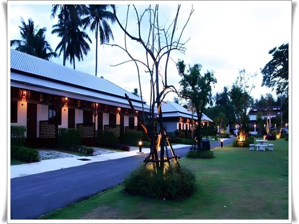 einen Park mit einem Baum und einem Gebäude in der Unterkunft Pilton Resort in Ban Huai Yang