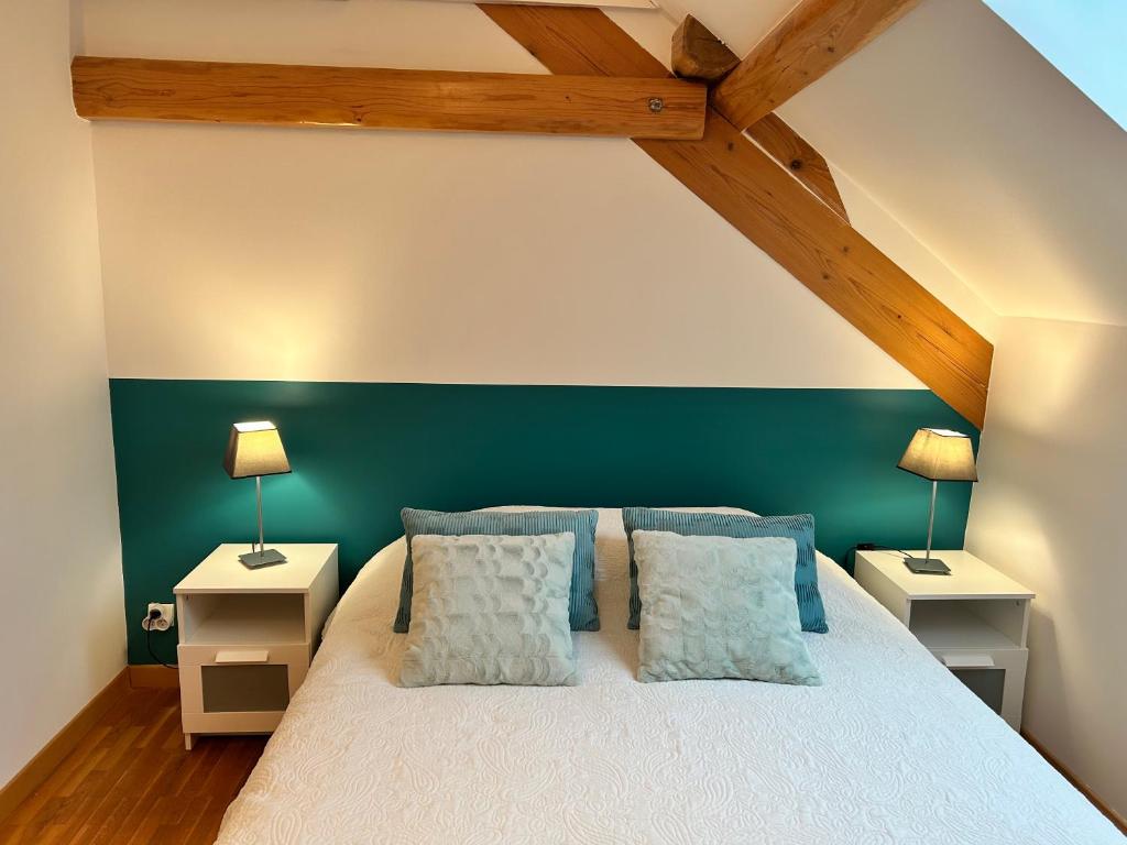 ein Schlafzimmer mit einem weißen Bett und zwei Nachttischen in der Unterkunft Apartment thermale luxeuil in Abelcourt