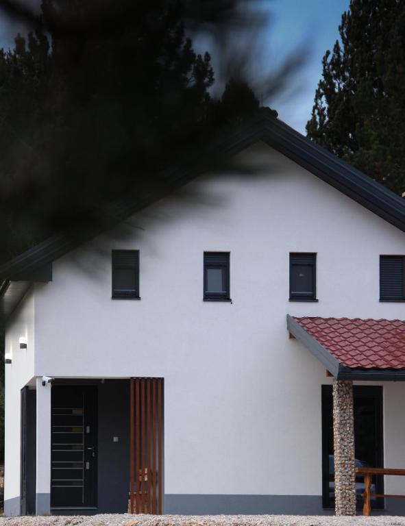 a white house with a black door at The Rest Nest in Risovac