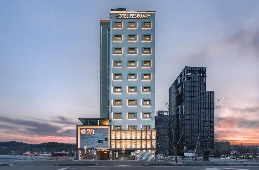 ein hohes Gebäude mit einem Schild auf dem Dach in der Unterkunft Daegu February Hotel Lions Park in Daegu
