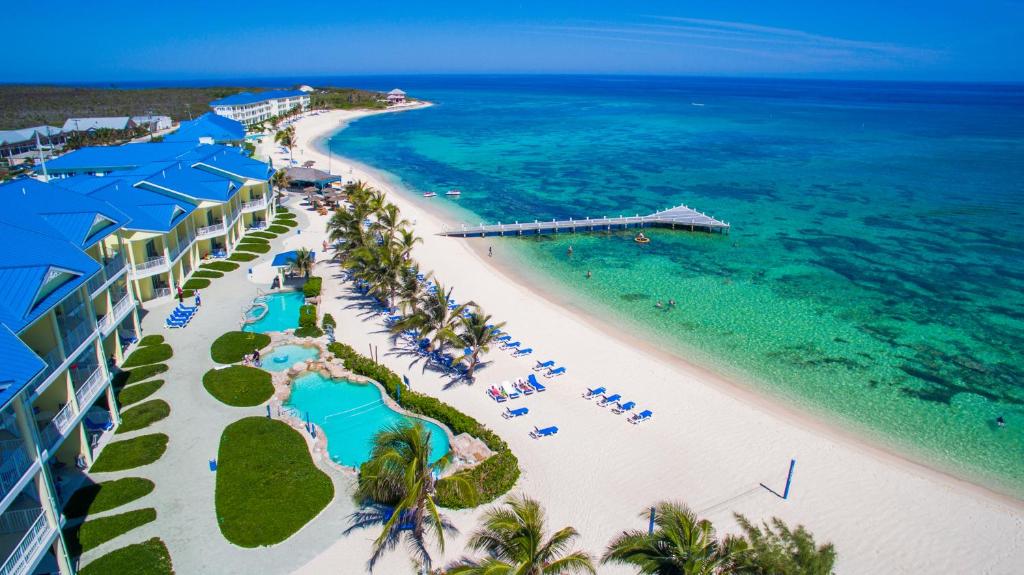 an aerial view of a beach with blue umbrellas at Wyndham Reef Resort, Grand Cayman in Sand Bluff