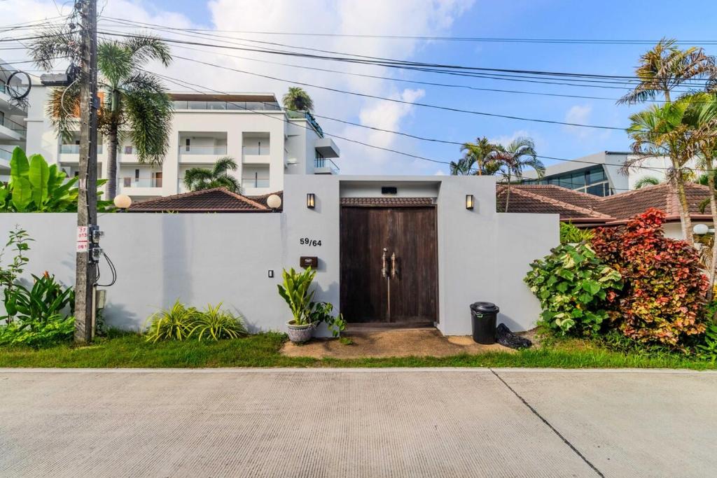 uma casa com uma porta castanha num quintal em V265 2BR Pool Villa Near Fitness Gyms Muay Thai em Ban Saiyuan (1)