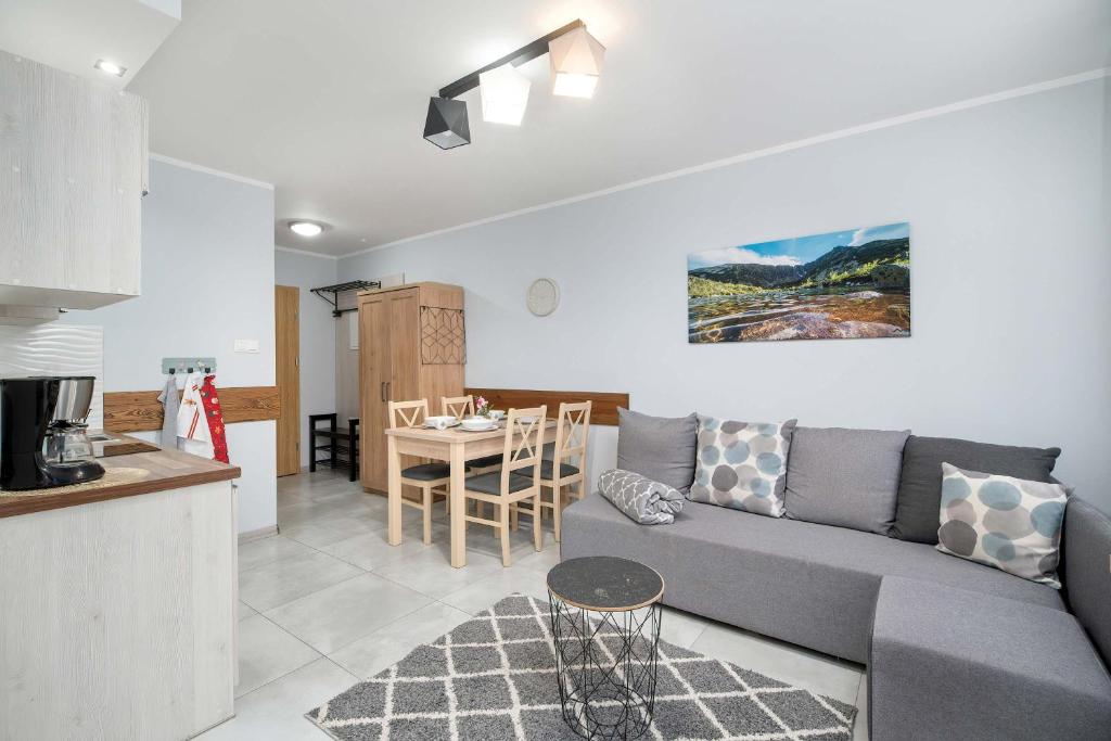 a living room and kitchen with a couch and a table at Charming Studio with Parking and Balcony in Karpacz by Noclegi Renters in Karpacz