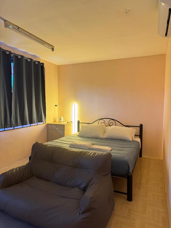 a bedroom with a bed and a couch in it at Mood Resotel Kamala in Kamala Beach