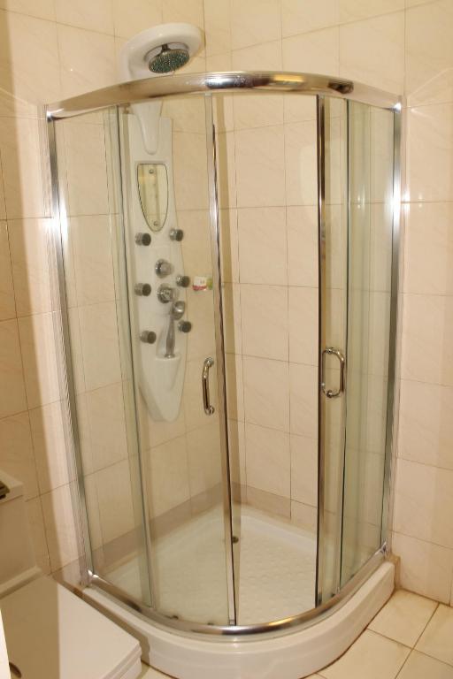 a shower with a glass door in a bathroom at Hotel Residence Flamani in Lomé