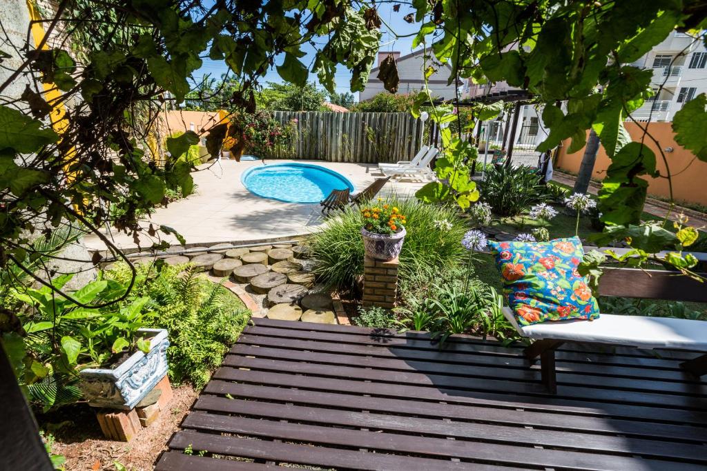 um jardim com um banco e uma piscina em Cabanas da Lua em Florianópolis
