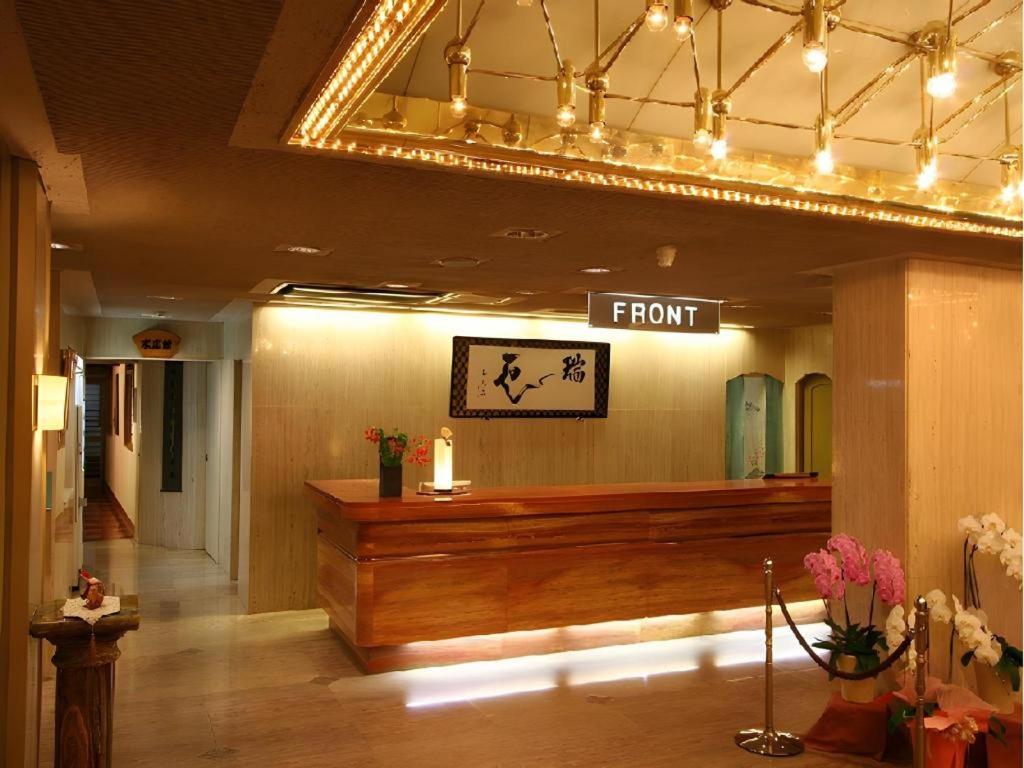 La réception d'un salon de coiffure avec une pancarte indiquant « Accueil ». dans l'établissement Tsukino Sumika Atami Juraku Hotel, à Atami