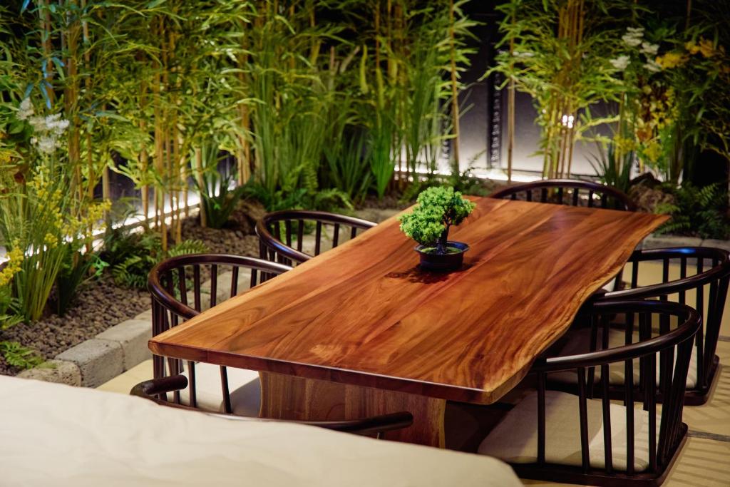 a wooden table with chairs and a potted plant on it at 컬리넌 호텔 앤 스파 in Seoul