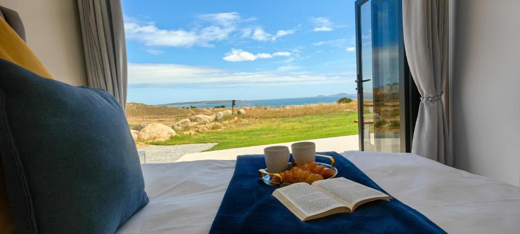 a bed with a view of the ocean from a window at Black Eagle's Rest #Unit 1-8 in Langebaan