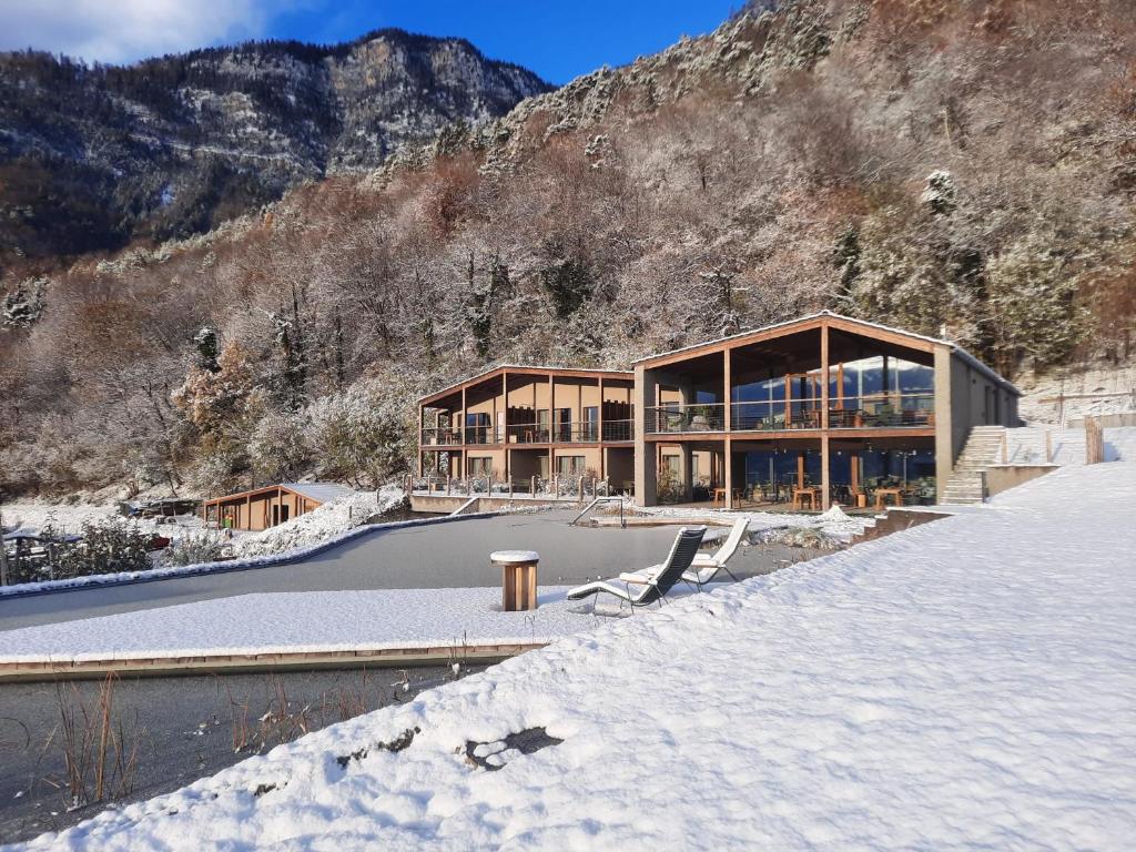 a house in the mountains with snow on the ground at Nikolausberg - Hof im Garten in Caldaro