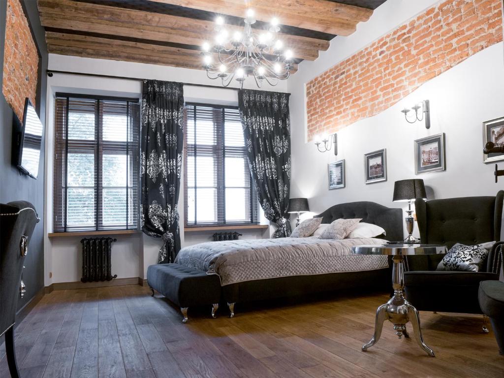 um quarto com uma cama e uma parede de tijolos em Leonardo 2 em Cracóvia