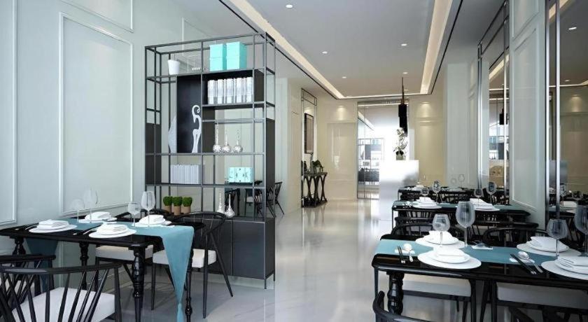 ein Restaurant mit Tischen und Stühlen in einem Raum in der Unterkunft Xana Hotelle·Heze Railyway Station in Zhaolou