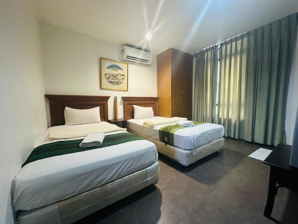 a hotel room with two beds and a television at J Hotel Bukit Bintang in Kuala Lumpur