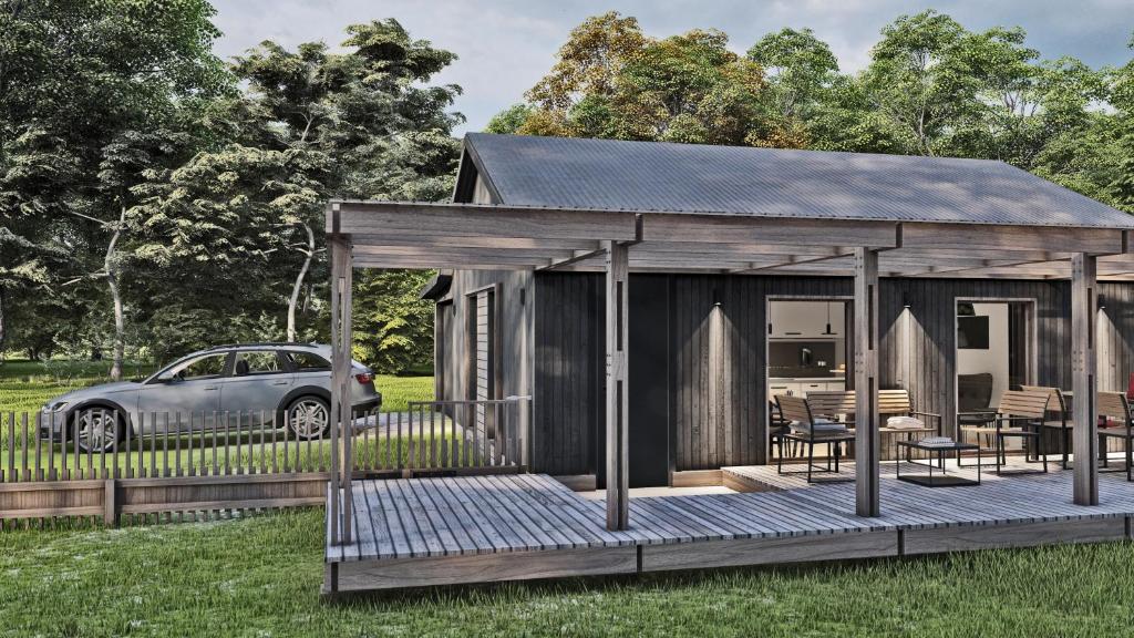 a cabin with a car parked in the grass at Ljungskile modern country lodge 