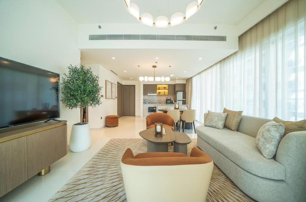 a living room with a couch and a tv at Zapbed House -Elegant 1 BR Apartment Grand Bleu Emaar Beachfront in Dubai