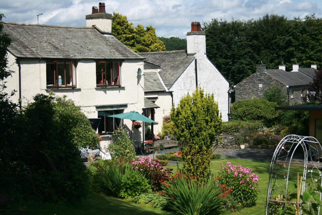 a white house with a garden in front of it at School House Cottage B&B and tea garden in Hawkshead