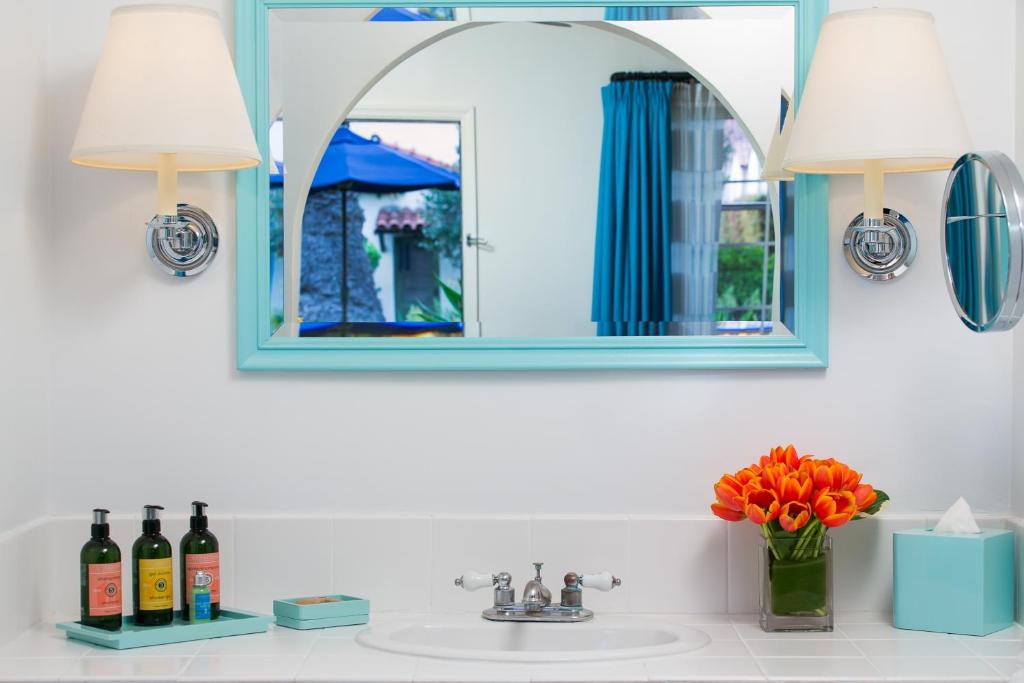 a bathroom sink with two lights and a mirror at The Milo in Santa Barbara