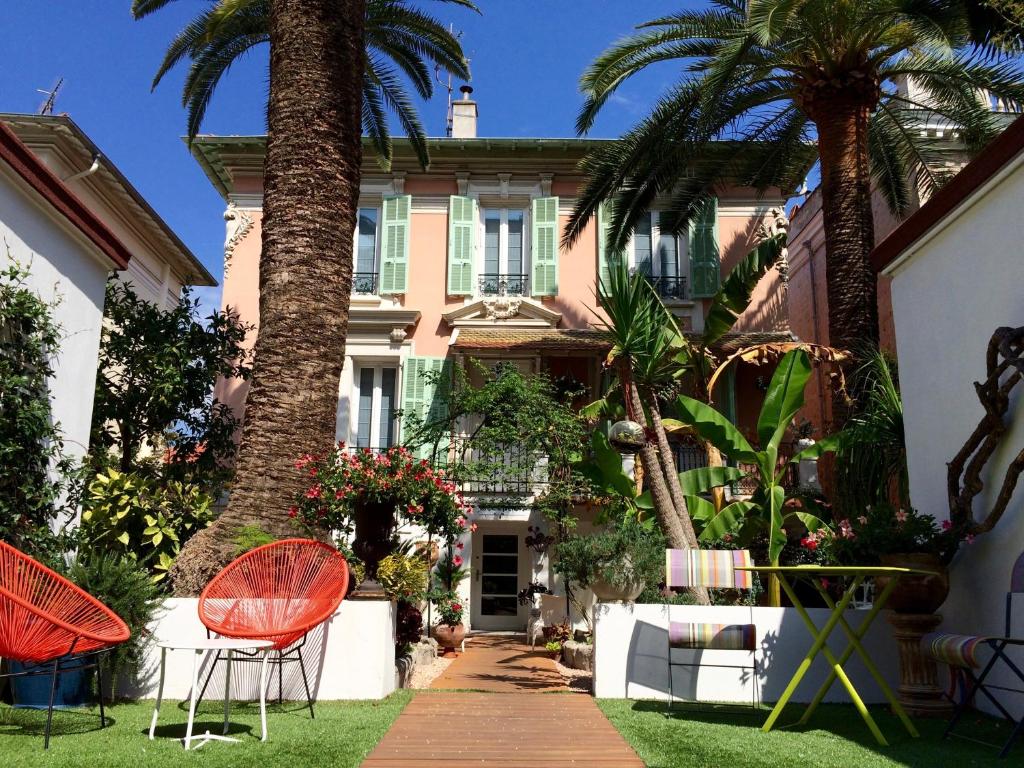 a patio with chairs, tables, and a lawn chair at Hotel Villa Rose in Nice
