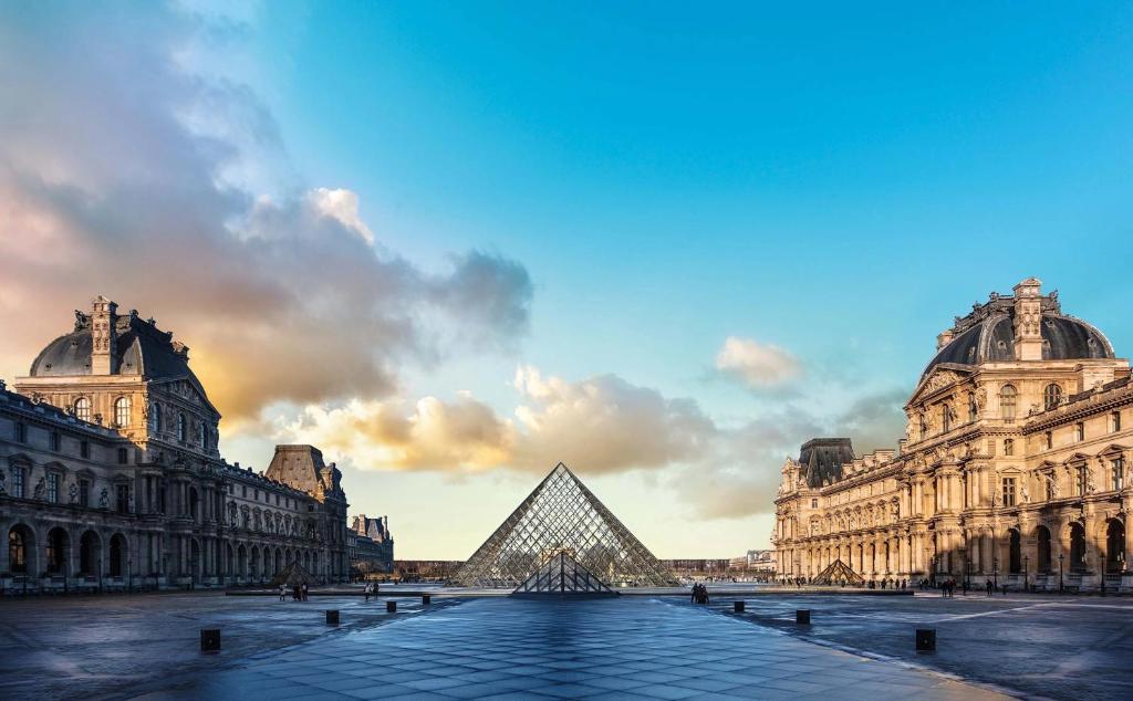 uma vista para a pirâmide de Louvre e para o edifício de Louvre em WS Louvre - Tuileries em Paris