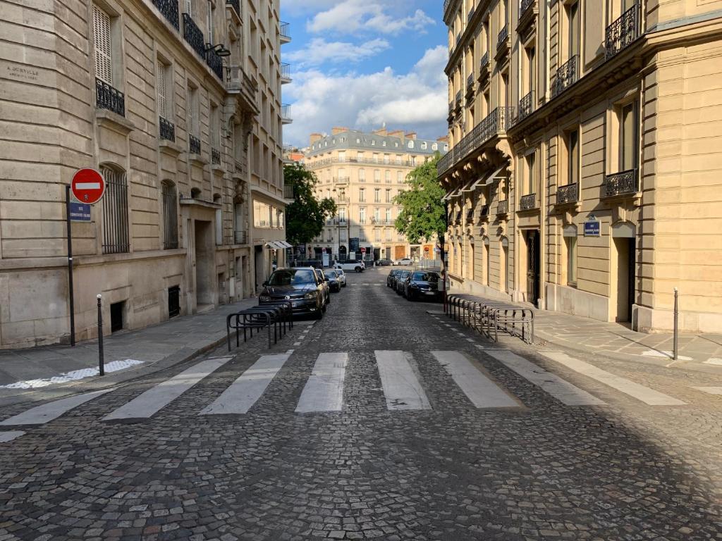 uma rua de calçada com carros estacionados e edifícios em WS Champs-Elysées - Colomb em Paris