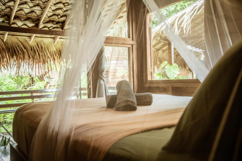 Bett in einem Zimmer mit Moskitonetz in der Unterkunft Hideaway, Koh Lipe in Ko Lipe